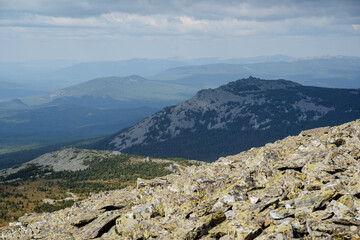 High kurum peaks, mountains crumbled, large stones on the slopes of the ridge, a panorama of steep mountains, haze in the air, the southern Urals, the beauty of Russia