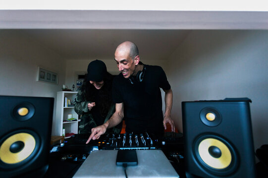 Couple of DJs mixing music on console