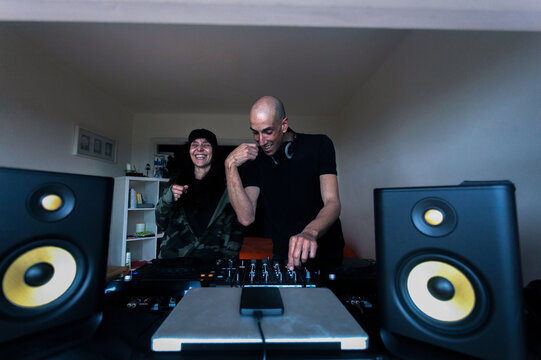 Couple of DJs mixing music on console