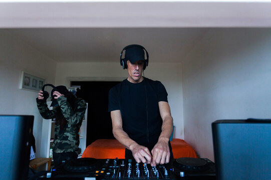 Couple of DJs mixing music on console
