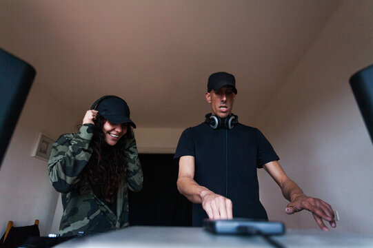 Couple of DJs mixing music on console