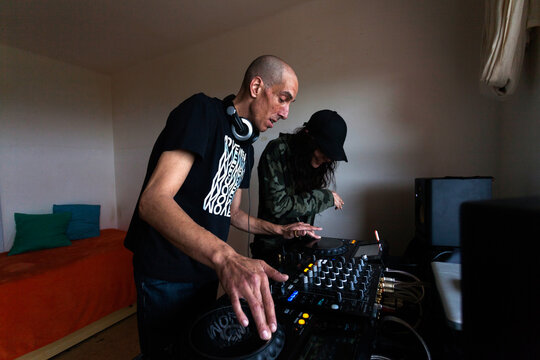 Couple of DJs mixing music on console