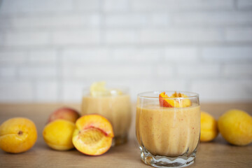 Smoothie drinks made from fresh peach and apricots, milk (yogurt) and oatmeal, garnished with peach slices, place for text. Healthy eating, detox, diet. Smoothies are prepared in a blender