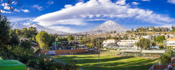 Panorama of Chachani and Misti Volcano and beautiful cloud formation with football stadium in...