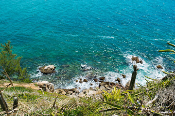 View from above the rocks at Praia dos Foguetes, close to the city of Cabo Frio, blue sea and surrounding vegetation.