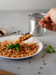 Baked Beans in tomato sauce in a plate against a grey background. Food. Food background