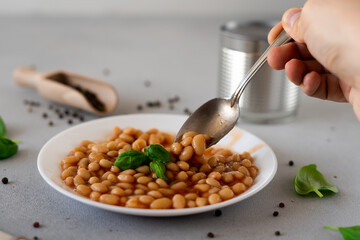 Baked Beans in tomato sauce in a plate against a grey background. Food. Food background