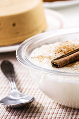 Mungunzá, or Canjica, a traditional sweet from the Brazilian June festivals, with typical Brazilian sweets and a pocket in the background, typical food of the June festivities