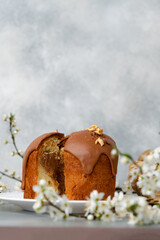 Cut Easter cake on plate decorated with spring flower branches