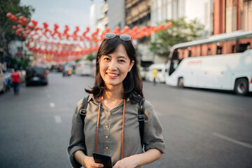 Young Asian woman backpack traveler enjoying China town street food market in Bangkok, Thailand. Traveler checking out side streets.