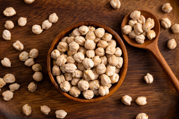 Fototapeta na wymiar Chick pea uncooked beens. Studio shoot on wooden background. Beans spread on rustic scene.Up view shoot.