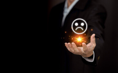 Unhappy Client hand pressed the unhappy face emoticon on the virtual touch screen on smartphone,customer satisfaction survey concept..