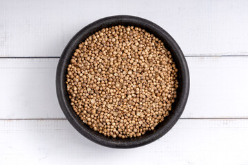 Coriander seeds bowl. Studio shoot isolated on rustic background. Up view shoot.