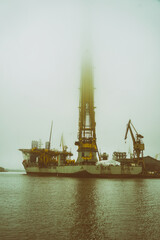 Ogromny statek z dźwigiem do montażu instalacji wiatrowych na morzu. Mglisty pochmurny dzień.  © Aneta