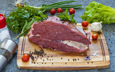 A piece of raw meat close-up on a dark background.
