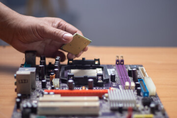 Fototapeta na wymiar Technician preparing to assemble CPU into motherboard