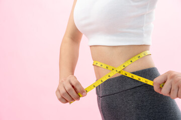 Diet and dieting. Beauty slim female body use tape measure. Woman in exercise clothes achieves...