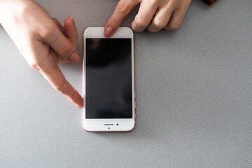 Blank smartphone held in hand in blue protective glove, isolated on white background. Copy space for a text.