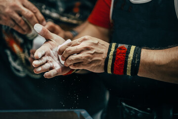 male powerlifter applying gym chalk on his hands before bench press powerlifting competition