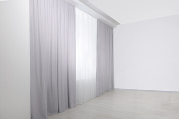 Fototapeta premium Light grey window curtains and white tulle indoors