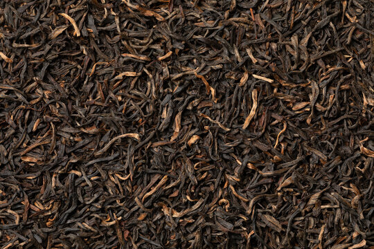 Indian Assam black Harmutty dried tea leaves full frame close up as background