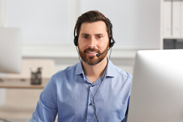 Hotline operator with headset working in office