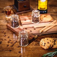 many coffee beans placed around and sugar on a wooden table in a warm, light atmosphere, on dark background, with copy space.