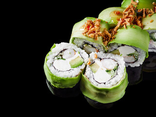 sushi roll green dragon with shrimp avocado cucumber cream cheese on a black mirror background