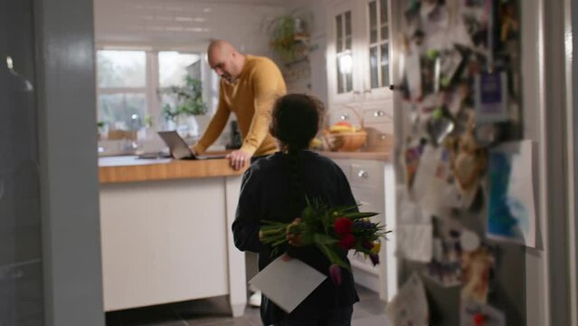 Boy with Down syndrome giving father flowers and card