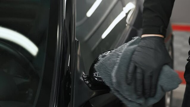 Putting paint protection fim with a cloth onto a car mirror. High quality 4k footage