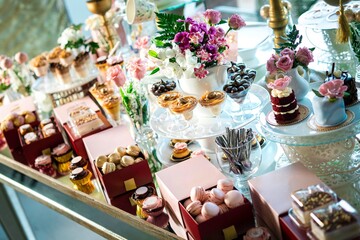 Delicious and tasty dessert table with cupcakes, mousses, and chocolates