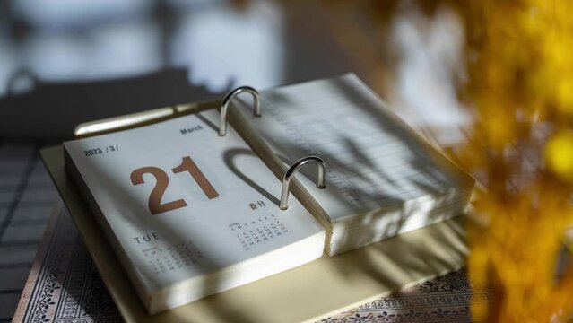Time lapse of fast flipping of torn diary desktop calendar on the table with sunlight