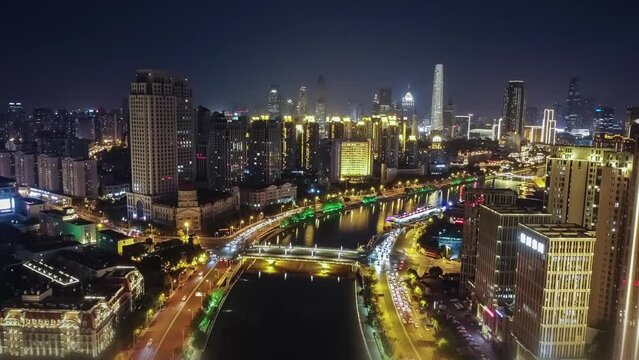 Time lapse aerial cityscape footage of illuminated skyscrapers with fast cars at night