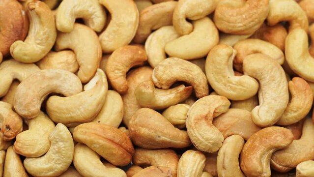 Cashew Pieces on a turntable from overhead.  Plant based ingredient.
Dried cashew nuts. Macro shot. Raw snack. Pile cashew nuts without shell, rotates, close up. Whole nut kernels. Rotation
