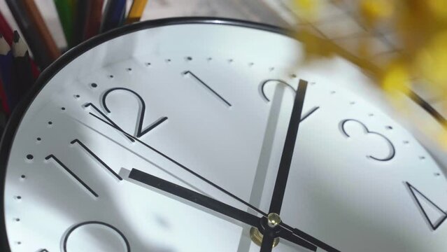 Closeup video of moving hand on the wall clock at 11 o'clock