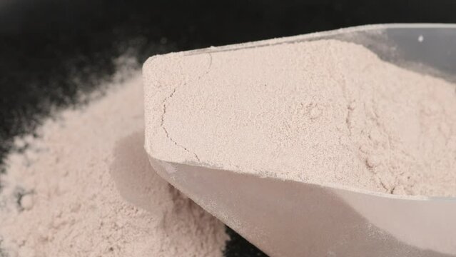 Gainer sports nutrition in powder in a scoop.