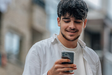 young man in the street looking at the mobile phone