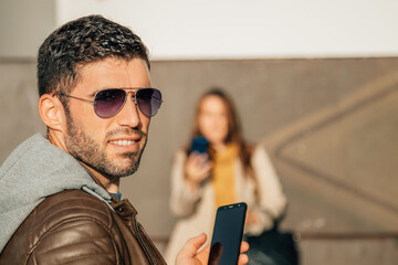 portrait of man with sunglasses in the street looking at camera