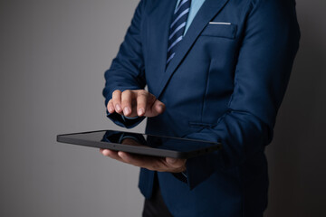 Close up view of young businessman using tablet to analyse the financial plan in the office room.