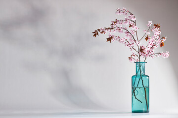 cherry blossom ikebana in a blue vase