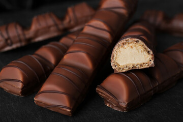 Tasty chocolate bars on black table, closeup