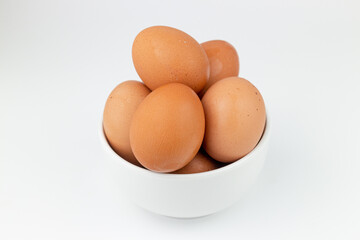 Eggs in a white bowl on a white background close-up