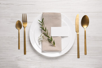 Stylish setting with cutlery, eucalyptus leaves and blank card on white wooden table, flat lay. Space for text - obrazy, fototapety, plakaty