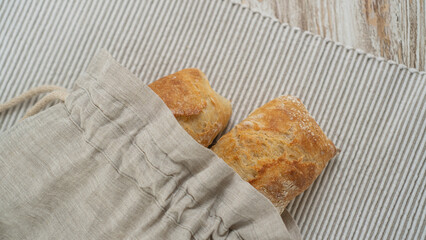 Freshly baked ciabatta showcased in a sustainable bread bag, resting on a rustic table adorned with a cozy tablecloth.