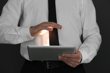 Closeup view of businessman using new tablet on black background