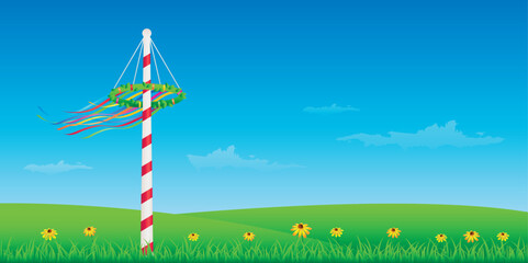 maypole with colorful ribbons on green meadow