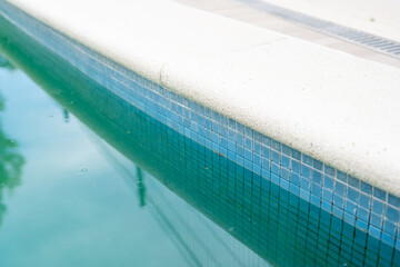 Swimming pool with dirty green water close-up.