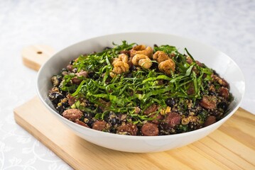 Wooden cutting board, featuring a bowl filled with a variety of beans and leafy greens