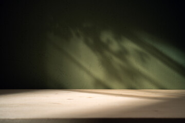 Empty table on khaki green texture wall background. Composition with leaves shadows on the wall and...