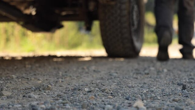 Man in rough boots gets out of an SUV. tourism, travel. Far from home and the big city.